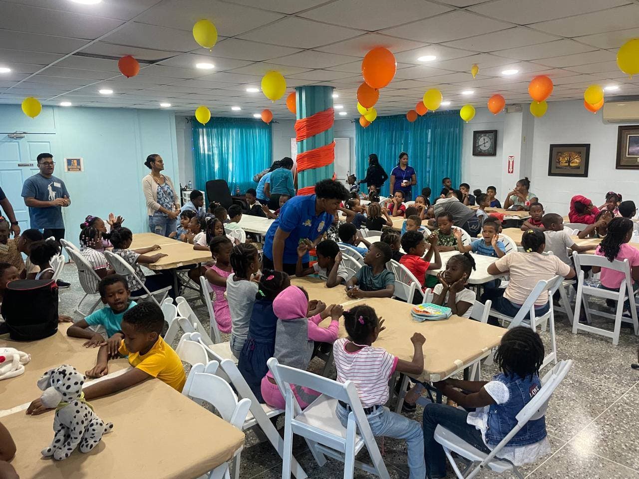 Children posing with costumed characters in front of the VBS Heroes of Faith banner